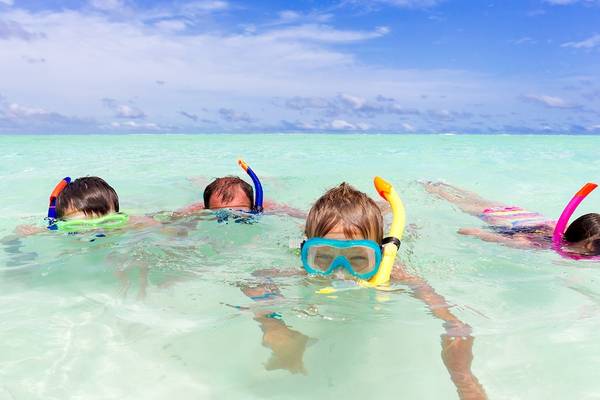 Vier Kinder tauchen im klaren Wasser der Malediven, Innahura Maldives Resort