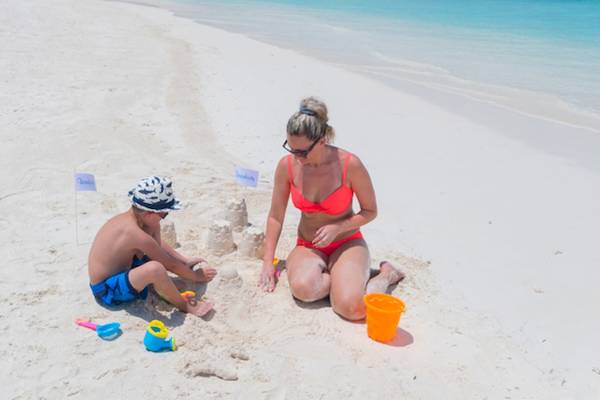 Mutter und Sohn bauen eine Sandburg am Strand des Innahura Maldives Resorts.