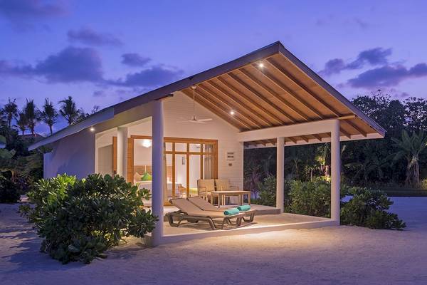Außenbereich des Innahura Maldives Resorts mit zwei Liegestühlen und einer Terrasse