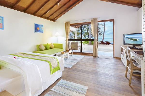 Innenansicht eines Zimmers im Innahura Maldives Resort mit Blick auf das Meer.