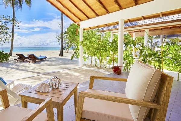 Terrasse des Innahura Maldives Resorts mit Blick auf den Strand, Liegen und Meer.