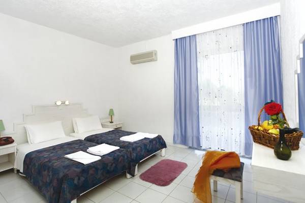 Doppelbettzimmer im Golden Star Hotel auf Kos mit frischen Handtüchern und Obstkorb.