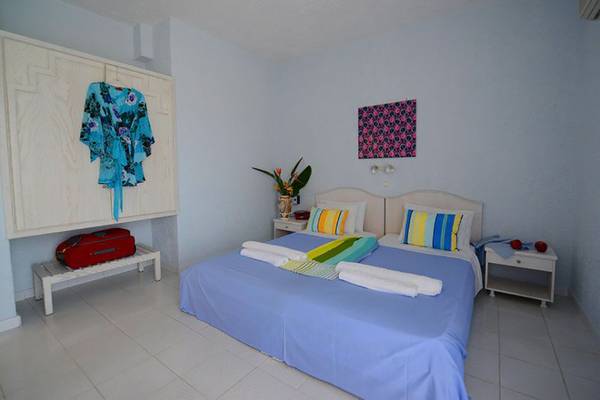 Schlafzimmer im Golden Star Hotel in Kos mit blauem Bett und weißen Möbeln.