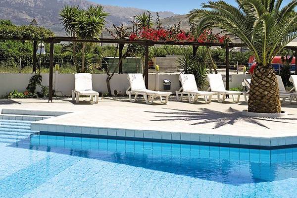 Außenpool des Golden Star Hotels mit Liegestühlen und Palmen im Hintergrund.