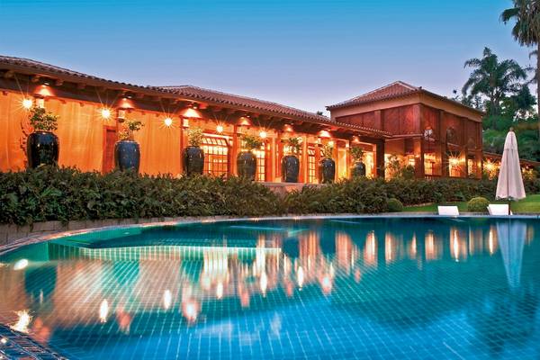 Außenansicht des Botanico & The Oriental Spa Garden Hotels mit Swimmingpool und illuminierten Gebäuden