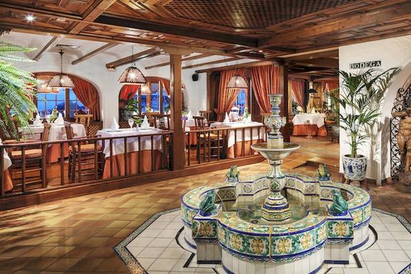 Innenansicht des Restaurants im Botanico & The Oriental Spa Garden Hotel mit einer Brunneninstallation in der Mitte des Raumes.