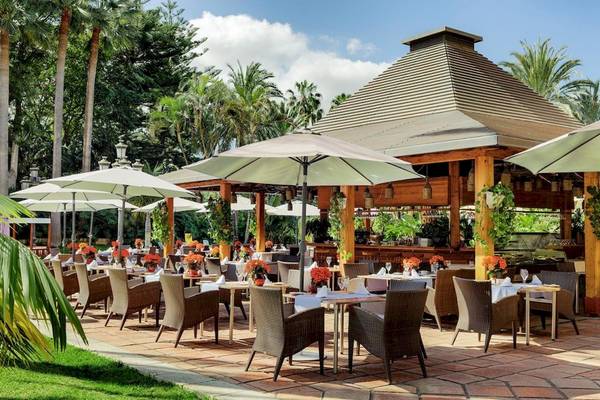 Außenbereich des Botanico & The Oriental Spa Garden Hotels mit bewirteten Tischen und exotischen Pflanzen