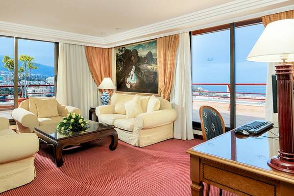 Wohnzimmer mit Meerblick im Botanico Hotel mit Sofas, Tisch, Lampe und Gemälde.