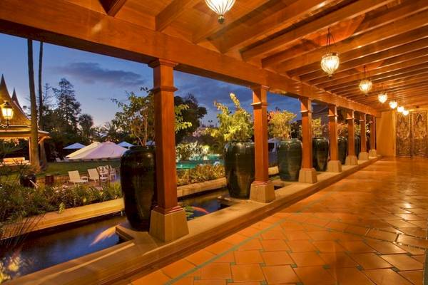 Außenbereich des Botanico & The Oriental Spa Garden Hotels mit überdachtem Gang, hängenden Laternen und Swimmingpool.