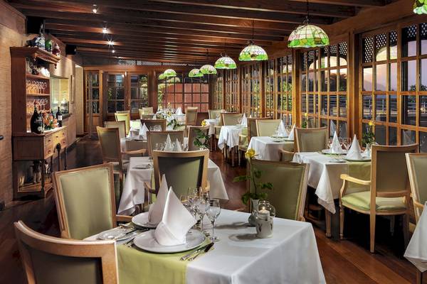 Innenansicht des Restaurants Botanico & The Oriental Spa Garden mit gedeckten Tischen und viktorianischen Lampen.