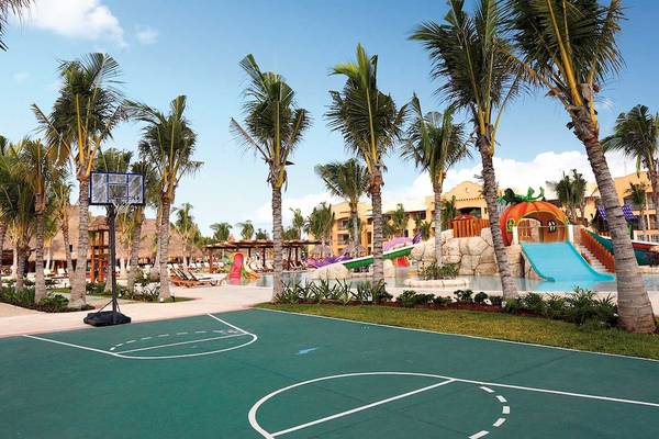 Außenbereich des Barcelo Maya Palace Hotels mit Basketballplatz und Wasserrutschen