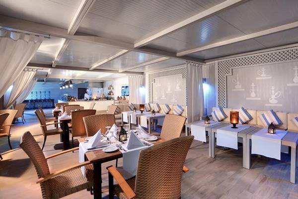Innenbereich des Jaz Aquaviva Hotels mit Tischen, Stühlen und weißen Möbeln.