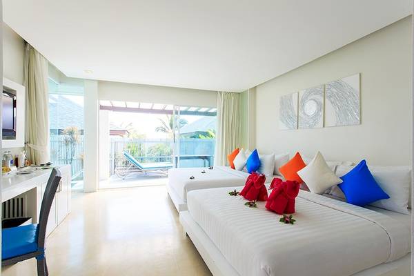 Doppelzimmer im Samui Resotel Beach Resort mit zwei Betten, bunten Kissen und einem Balkon.