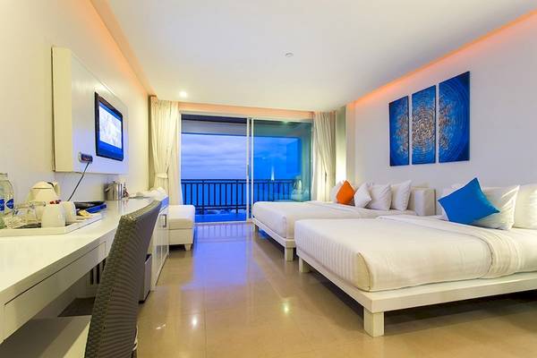 Innenansicht eines Zimmers im Samui Resotel Beach Resort mit zwei Betten, Schreibtisch und Meerblick.