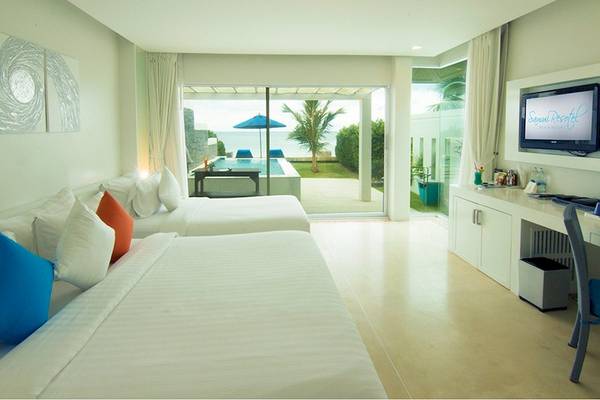 Doppelzimmer mit Meerblick im Samui Resotel Beach Resort, mit zwei Betten, einem Schreibtisch und einem Fernseher.