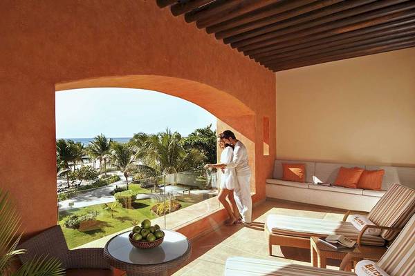 Paar auf dem Balkon des Barcelo Maya Palace mit Blick auf den Strand und das Meer