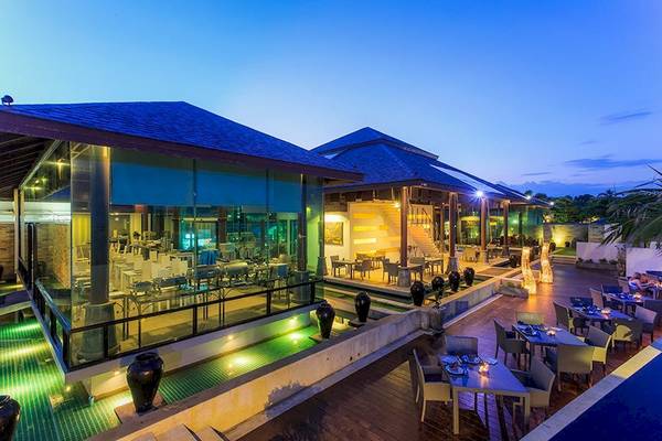Außenbereich des Samui Resotel Beach Resorts bei Nacht mit Glasfassade und Außenbestuhlung.