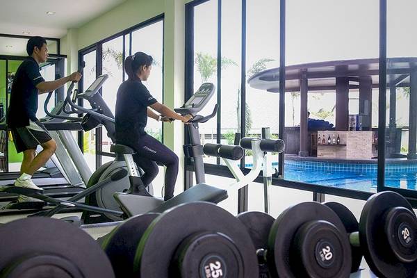 Fitnessbereich im Samui Resotel Beach Resort mit Cardiogeräten und Blick auf den Pool