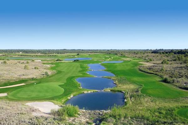Luftaufnahme des MIRA Acaya Golf Resort & SPA mit mehreren Wasserhindernissen auf dem Golfplatz.