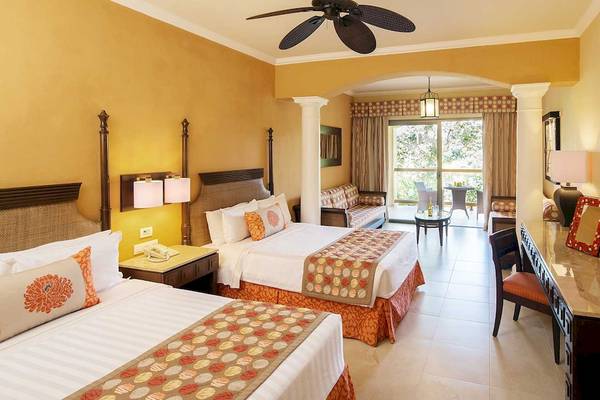 Doppelzimmer im Barcelo Maya Palace mit zwei Betten, Klimaanlage, Fernseher und Balkon.