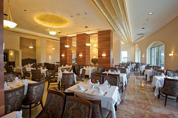 Innenansicht des Restaurants im Melas Lara Hotel mit gedeckten Tischen und eleganter Einrichtung.