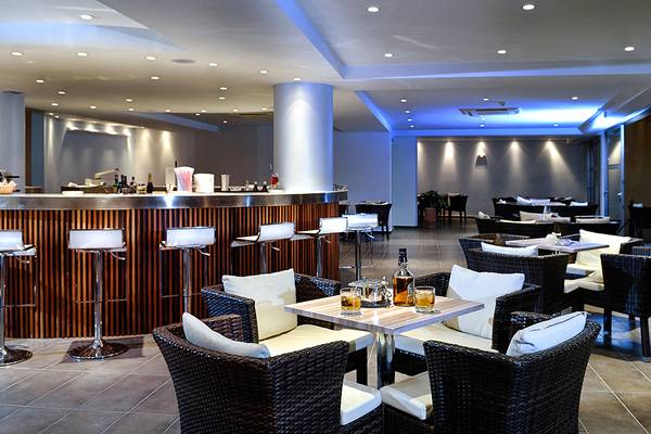Innenbereich des Blue Marine Resort & Spa mit Bar, Tischen und Stühlen.