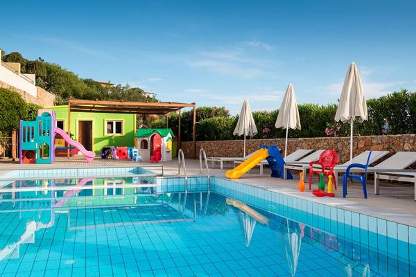 Außenbereich des Blue Marine Resort & Spa mit Kinderpool, Spielgeräten und Sonnenliegen.