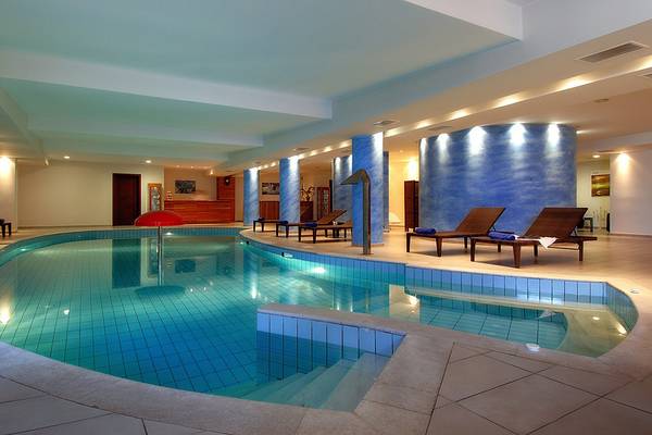 Innenpool des Blue Marine Resort & Spa mit blauen Wänden und Liegen.