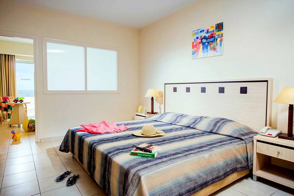 Hotelzimmer im Blue Marine Resort & Spa mit Bett, Nachttischen und Fenstern.
