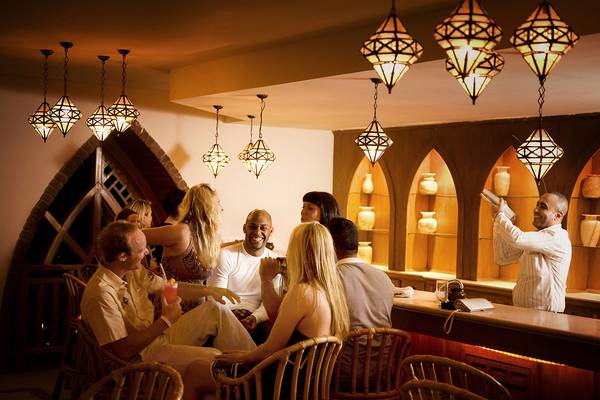 Gäste sitzen an der Bar im Grand Hotel Sharm El Sheikh und genießen Getränke.