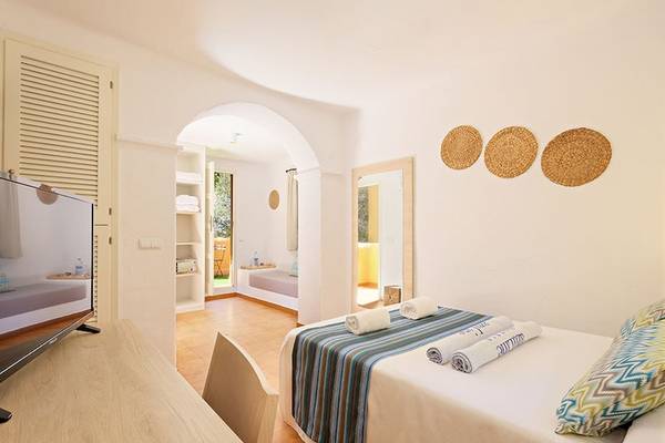 Schlafzimmer im Cala Martina by Llum Hotel mit Fernseher und bequemem Bett.