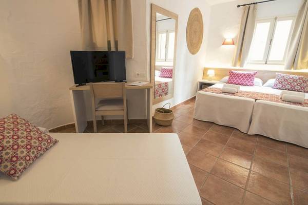 Innenansicht eines Doppelzimmers im Cala Martina by Llum Hotel mit zwei Betten, Schreibtisch und Fernseher.