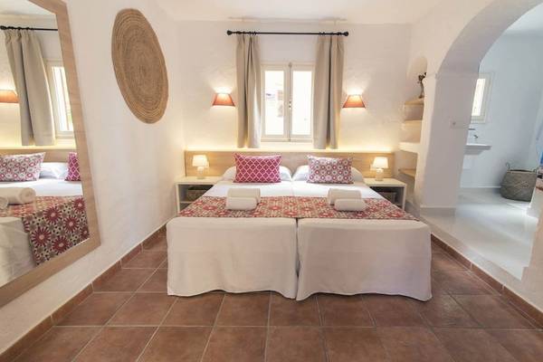 Doppelzimmer im Cala Martina by Llum Hotel mit zwei Betten, Tischlampen und einem Spiegel.