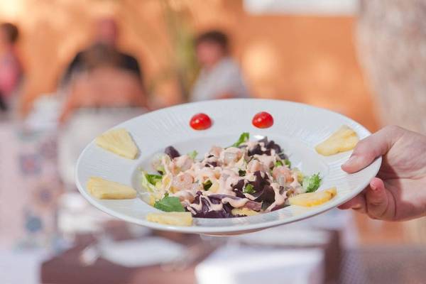 Ein Salat auf einem weißen Teller mit Tomaten und Ananas im Restaurant.