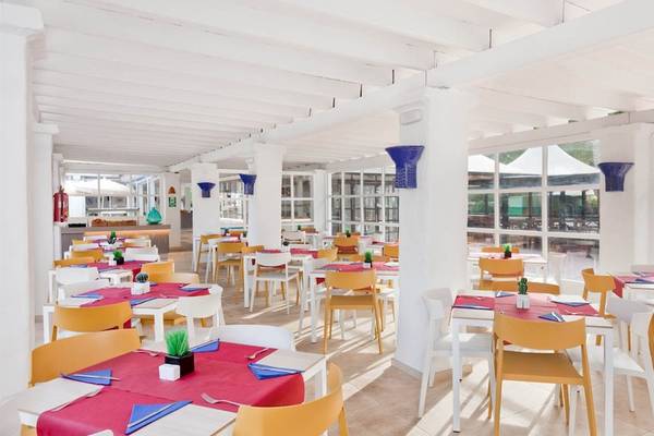 Innenansicht des Restaurants im Cala Martina by Llum Hotel mit runden Tischen und Stühlen.