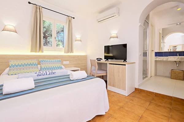 Hotelzimmer im Cala Martina by Llum mit Bett, Fernseher, Schreibtisch und Badezimmer
