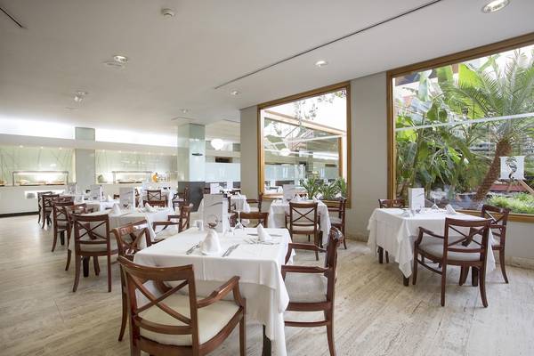 Innenansicht des Restaurants im Hipotels La Geria mit gedeckten Tischen und Stühlen.