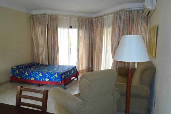 Hotelzimmer im ROC Arenas Doradas mit Bett, Stühlen, Tisch und Lampe.