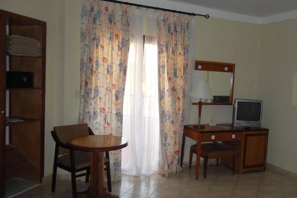 Das Zimmer im ROC Arenas Doradas Hotel mit Tisch, Stuhl, Fernseher und Schreibtisch.