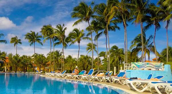Außenpool des ROC Arenas Doradas Hotels mit Palmen und Sonnenliegen.