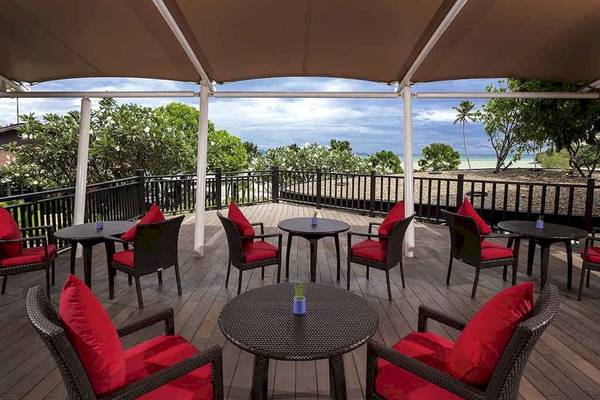 Ausblick von der Terrasse des Pullman Phuket Panwa Beach Resort mit roten Kissen und Tischen.