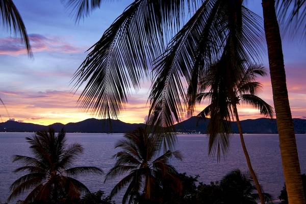 Sonnenuntergang über dem Pullman Phuket Panwa Beach Resort mit Blick auf das Meer und die Berge.