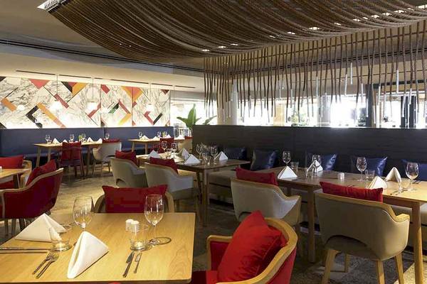 Innenansicht des Restaurants im Pullman Phuket Panwa Beach Resort mit eingerichteten Tischen und Stühlen.