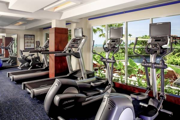 Fitnesscenter im Pullman Phuket Panwa Beach Resort mit mehreren Laufbändern und Blick auf einen See.