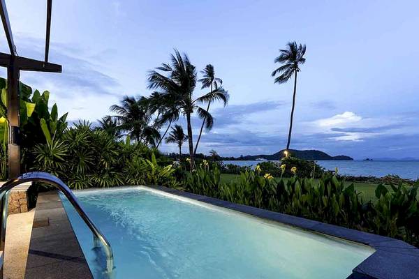 Außenpool des Pullman Phuket Panwa Beach Resorts bei Nacht mit Blick auf den Ozean und Palmen.