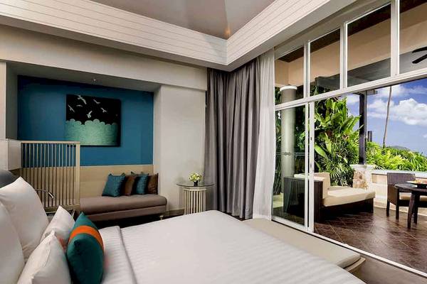 Schlafzimmer im Pullman Phuket Panwa Beach Resort mit Blick auf den Garten