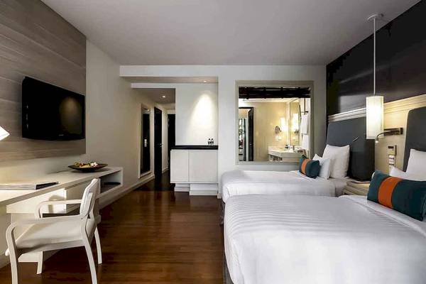 Hotelzimmer im Pullman Phuket Panwa Beach Resort mit zwei Betten, Schreibtisch und Fernseher