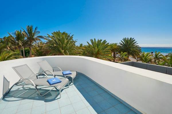 Balkon des Hipotels La Geria mit zwei Liegen und Blick auf Palmen und Meer