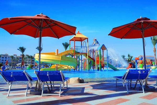 Wasserrutsche im Pickalbatros Dana Beach Resort mit bunten Liegestühlen und roten Sonnenschirmen.
