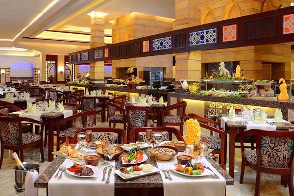 Restaurant im Pickalbatros Dana Beach Resort mit gefüllten Tischen und einer langen Theke.